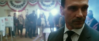 Movie still from “The Purge: Election Year” (2016), directed by James DeMonaco – A person wearing a suit and tie; Close Up shot, Low angle