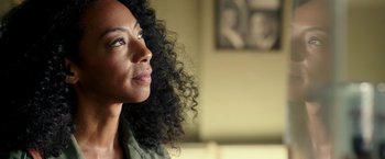 Movie still from “The Purge: Election Year” (2016), directed by James DeMonaco – A person with curly black hair; Close Up shot, Over the shoulder angle