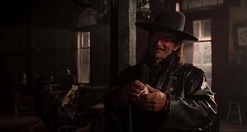 Movie still from “The Quick and the Dead” (1995), directed by Sam Raimi – A man wearing a hat and a leather jacket; Medium shot, Over the shoulder angle