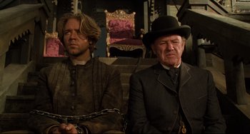 Movie still from “The Quick and the Dead” (1995), directed by Sam Raimi – Two men sitting next to each other with chains around their ankles; Medium shot, Low angle