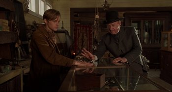 Movie still from “The Quick and the Dead” (1995), directed by Sam Raimi – A man in a top hat and a man in a brown jacket; Medium shot, Low angle