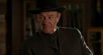 Movie still from “The Quick and the Dead” (1995), directed by Sam Raimi – An older man wearing a top hat and a suit; Close Up shot, Over the shoulder angle