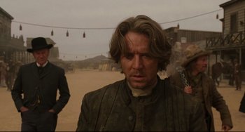Movie still from “The Quick and the Dead” (1995), directed by Sam Raimi – A person with long brown hair; Close Up shot, Over the shoulder angle