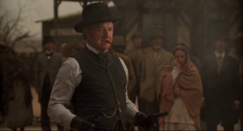 Movie still from “The Quick and the Dead” (1995), directed by Sam Raimi – An older man in a black hat smoking a pipe; Medium shot, Low angle