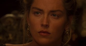 Movie still from “The Quick and the Dead” (1995), directed by Sam Raimi – A woman's face in a dimly - lit room; Close Up shot, Over the shoulder angle