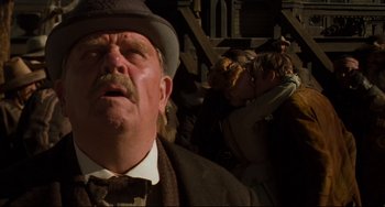 Movie still from “The Quick and the Dead” (1995), directed by Sam Raimi – An old man with a beard and a mustache wearing a hat and a tie; Close Up shot, Low angle