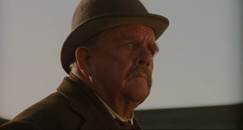 Movie still from “The Quick and the Dead” (1995), directed by Sam Raimi – An older man with a mustache wearing a hat; Close Up shot, Low angle