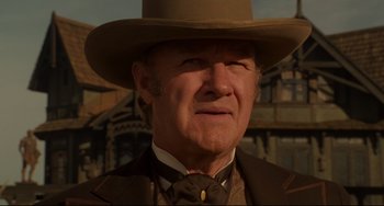 Movie still from “The Quick and the Dead” (1995), directed by Sam Raimi – An older man wearing a hat and a suit and tie; Close Up shot, Low angle