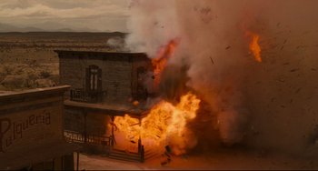 Movie still from “The Quick and the Dead” (1995), directed by Sam Raimi – An old building is being destroyed by a fire; Extreme Wide shot, Low angle