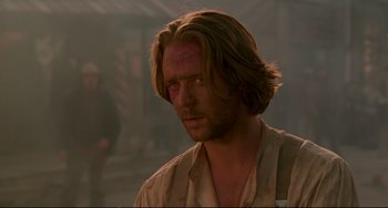 Movie still from “The Quick and the Dead” (1995), directed by Sam Raimi – A person with long blonde hair; Close Up shot, Over the shoulder angle