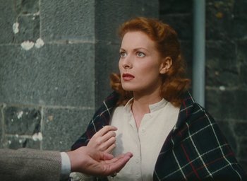 Movie still from “The Quiet Man” (1952), directed by John Ford – A woman with red hair is talking to a man; Medium shot, High angle