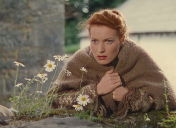 Movie still from “The Quiet Man” (1952), directed by John Ford – A woman laying on the ground next to daisies; Close Up shot, High angle