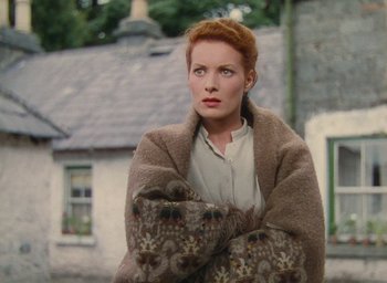 Movie still from “The Quiet Man” (1952), directed by John Ford – A red haired woman wrapped in a blanket; Medium shot, High angle