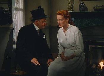 Movie still from “The Quiet Man” (1952), directed by John Ford – An older man and a younger woman sitting in a room; Medium shot, Low angle