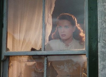 Movie still from “The Quiet Man” (1952), directed by John Ford – A woman looking out of a window at night; Medium shot, Low angle