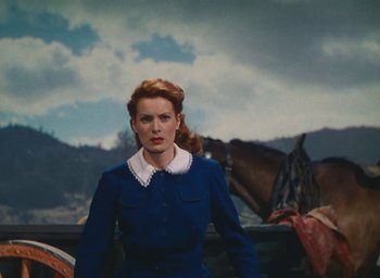 Movie still from “The Quiet Man” (1952), directed by John Ford – A woman standing in front of horses in a field; Medium shot, Low angle