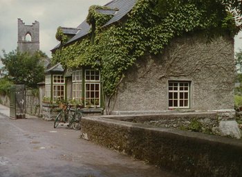Movie still from “The Quiet Man” (1952), directed by John Ford – A bicycle parked in front of a building with green ivy growing all over it; Extreme Wide shot, Low angle