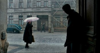 Movie still from “The Reader” (2008), directed by Stephen Daldry – A man and a woman walking down a street holding an umbrella; Wide shot, Over the shoulder angle