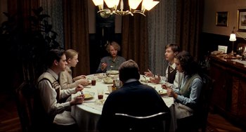 Movie still from “The Reader” (2008), directed by Stephen Daldry – A group of people sitting around a table eating food; Wide shot, High angle