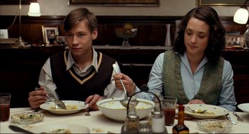 Movie still from “The Reader” (2008), directed by Stephen Daldry – A man and a woman sitting at a dinner table; Medium shot, Over the shoulder angle