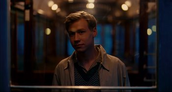 Movie still from “The Reader” (2008), directed by Stephen Daldry – A man in a tan jacket standing next to a train window; Close Up shot, Over the shoulder angle