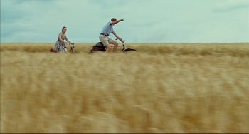 Movie still from “The Reader” (2008), directed by Stephen Daldry – A man riding a bike through a wheat field; Wide shot, Low angle