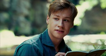 Movie still from “The Reader” (2008), directed by Stephen Daldry – A young man is holding a book in his hands; Close Up shot, Over the shoulder angle