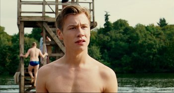 Movie still from “The Reader” (2008), directed by Stephen Daldry – A shirtless young man standing next to a body of water; Close Up shot, Over the shoulder angle