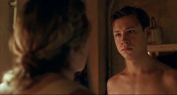 Movie still from “The Reader” (2008), directed by Stephen Daldry – A young man looking into a mirror while standing next to a woman; Close Up shot, Over the shoulder angle