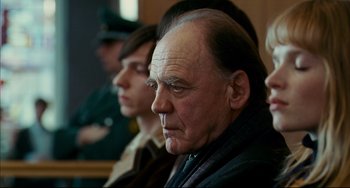 Movie still from “The Reader” (2008), directed by Stephen Daldry – An old man with a beard and mustache in a court room; Close Up shot, Over the shoulder angle