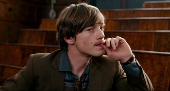 Movie still from “The Reader” (2008), directed by Stephen Daldry – A young man in a brown jacket is holding his hand to his face; Close Up shot, Over the shoulder angle