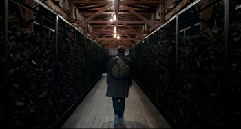 Movie still from “The Reader” (2008), directed by Stephen Daldry – A person with a backpack walking down a long hallway; Wide shot, Low angle