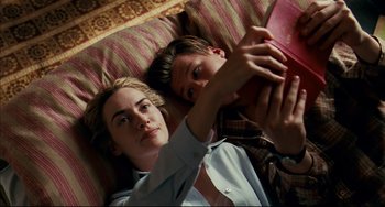 Movie still from “The Reader” (2008), directed by Stephen Daldry – A man and a woman laying on a bed; Medium shot, Overhead angle