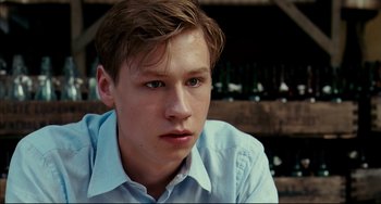 Movie still from “The Reader” (2008), directed by Stephen Daldry – A young man in a blue shirt is looking at the camera; Close Up shot, Over the shoulder angle