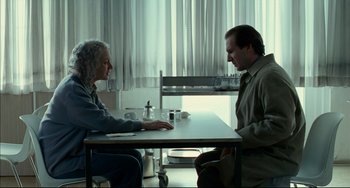 Movie still from “The Reader” (2008), directed by Stephen Daldry – A man and a woman sitting at a table in a room; Medium shot, Over the shoulder angle