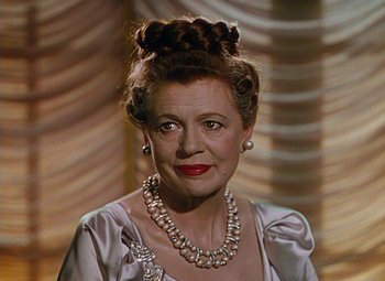 Movie still from “The Red Shoes” (1948), directed by Michael Powell – An older woman wearing a necklace and a dress; Close Up shot, Over the shoulder angle