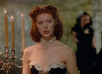 A woman with red hair wearing a black and white dress