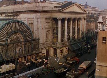 Movie still from “The Red Shoes” (1948), directed by Michael Powell – An aerial view of an old theater in the middle of a city; Extreme Wide shot, High angle