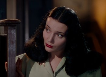 Movie still from “The Red Shoes” (1948), directed by Michael Powell – A woman with long black hair and red lipstick looking to her left; Close Up shot, Over the shoulder angle