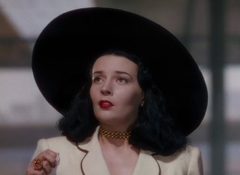 Movie still from “The Red Shoes” (1948), directed by Michael Powell – A woman in a black hat and a white jacket; Close Up shot, Low angle