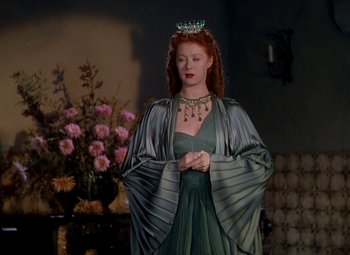 Movie still from “The Red Shoes” (1948), directed by Michael Powell – A woman wearing a green dress and a crown; Medium shot, Low angle
