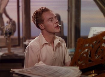Movie still from “The Red Shoes” (1948), directed by Michael Powell – A man sitting in front of an open piano; Medium shot, Low angle