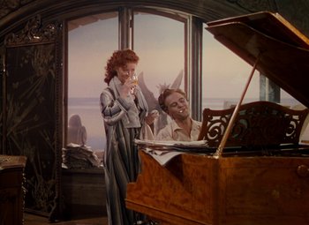 Movie still from “The Red Shoes” (1948), directed by Michael Powell – A man and a woman standing in front of a piano; Wide shot, High angle