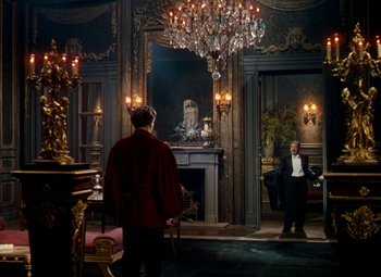 Movie still from “The Red Shoes” (1948), directed by Michael Powell – Two men in a room with a fireplace and chandelier; Wide shot, Over the shoulder angle