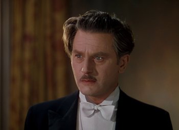 Movie still from “The Red Shoes” (1948), directed by Michael Powell – A person wearing a suit and bow tie; Close Up shot, Low angle