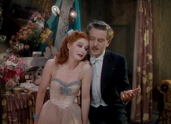 Movie still from “The Red Shoes” (1948), directed by Michael Powell – A man and a woman standing next to each other; Medium shot, High angle