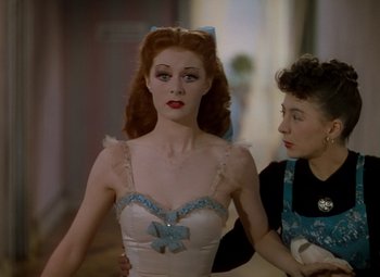 Movie still from “The Red Shoes” (1948), directed by Michael Powell – A woman in a white dress and a woman in a black dress; Medium shot, Over the shoulder angle