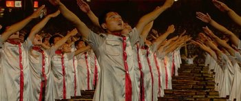 Movie still from “The Redeem Team” (2022), directed by Jon Weinbach – A group of people standing up with their hands up; Medium shot, Low angle