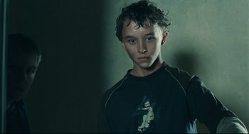 Movie still from “The Return” (2003), directed by Andrey Zvyagintsev – A young man in a black shirt is posing for a picture; Close Up shot, Low angle