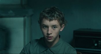 A young boy is looking into the camera